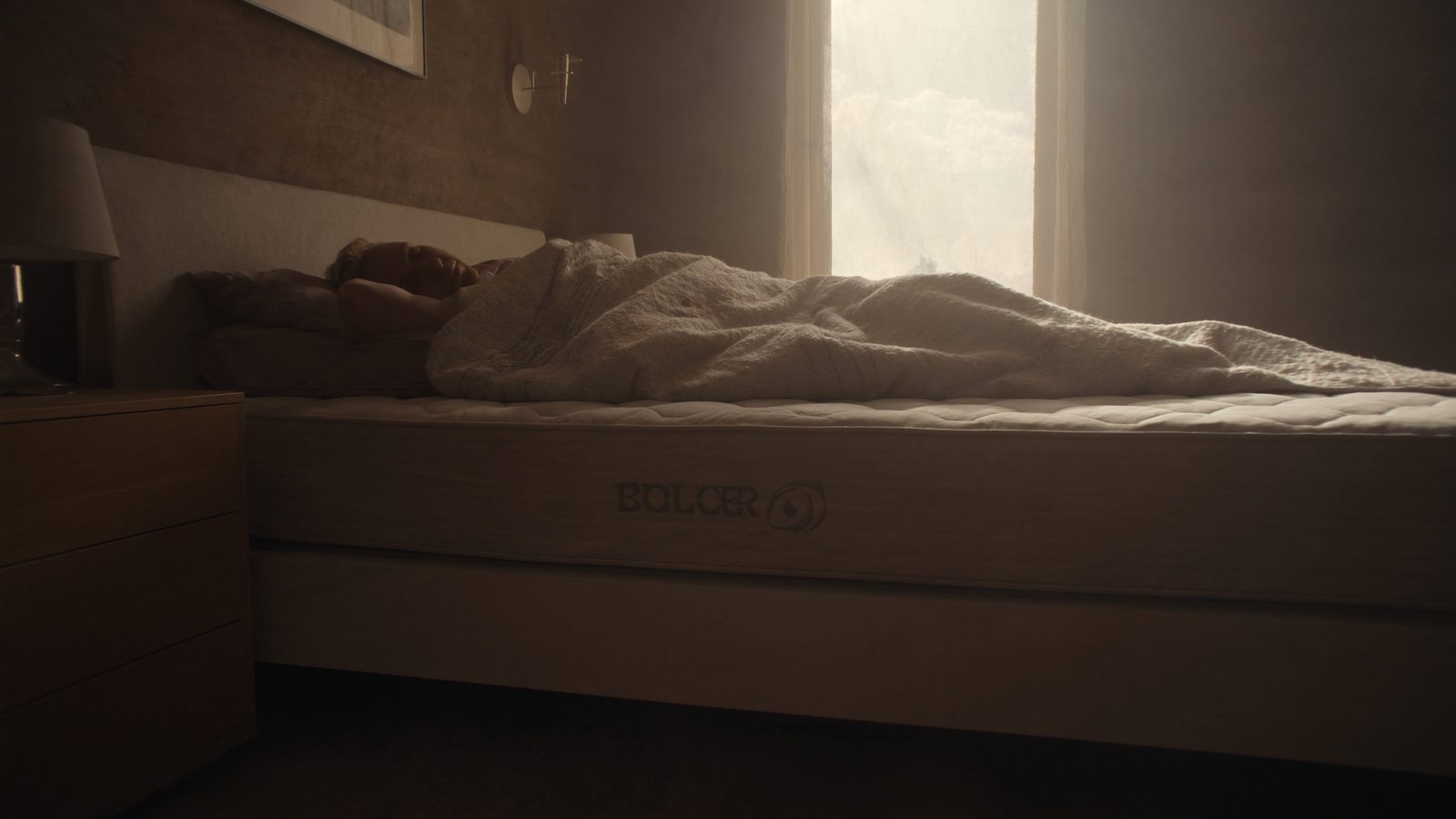 Canapé abatible abierto con la tapa levantada y ropa de cama guardada en el interior